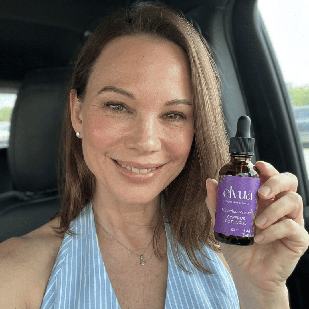 Eine lächelnde Frau hält eine Flasche Elvua Body Serum in einem Auto